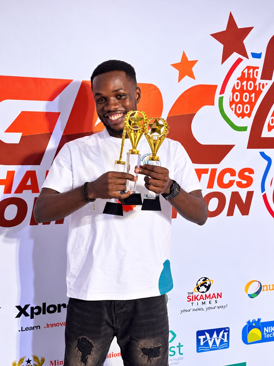 Team GCU member holding three trophies in front of the GRC 2026 backdrop